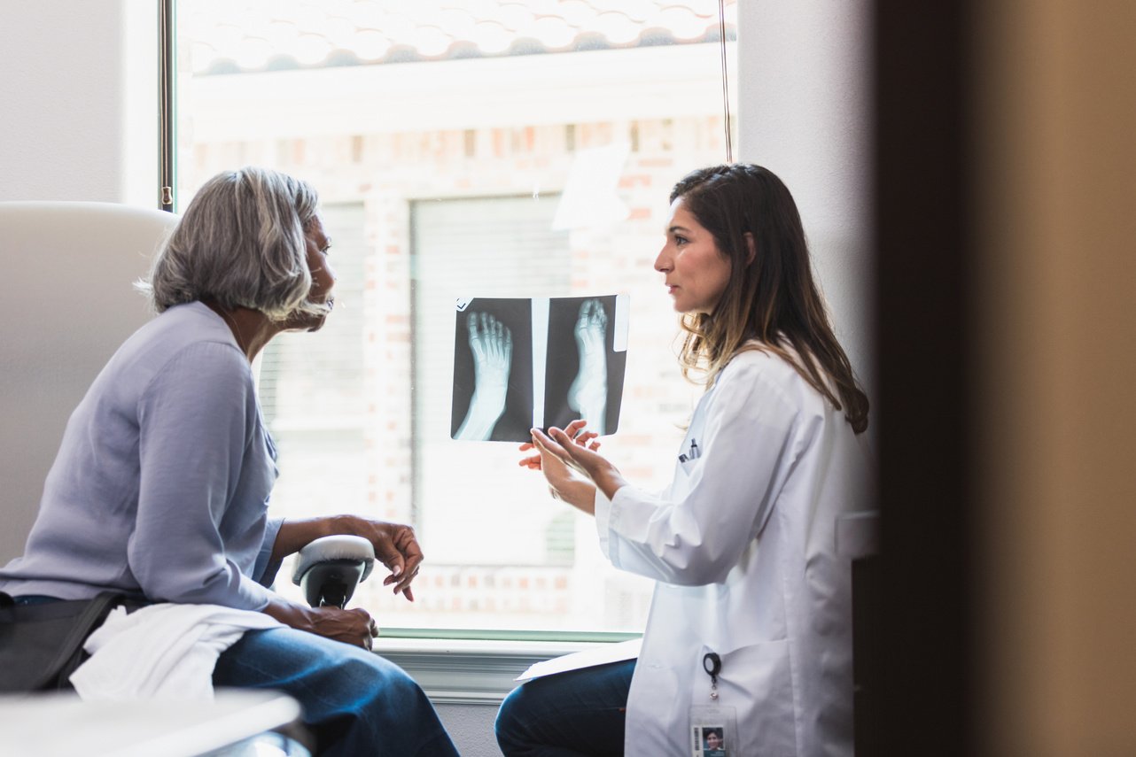 Caring doctor discusses patient's foot x-ray